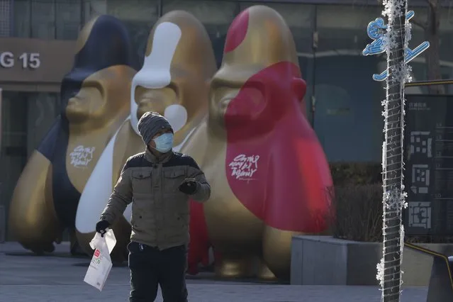 A man wearing a mask walks near decorations at a shopping mall in Beijing, China, Tuesday, December 14, 2021. Chinese state media said Monday, Dec. 13, 2021, that the first case of the omicron variant of COVID-19 has been detected in the country's mainland in Tianjin city just east of Beijing. (Photo by Ng Han Guan/AP Photo)