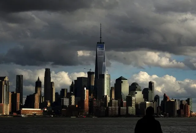 A man pauses in a park along the Hudson River in Hoboken, New Jersey April 7, 2016, as the skyline of New York's Lower Manhattan and One World Trade Center is pictured during sunset. (Photo by Yannis Behrakis/Reuters)