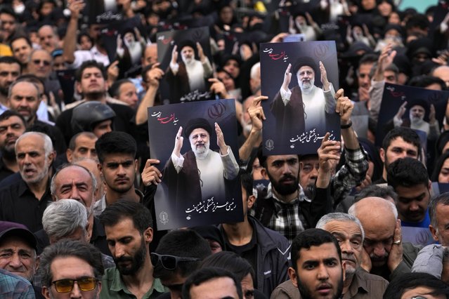 People hold up posters of President Ebrahim Raisi during a mourning ceremony for him at Vali-e-Asr square in downtown Tehran, Iran, Monday, May 20, 2024. Iranian President Raisi and the country's foreign minister were found dead Monday hours after their helicopter crashed in fog, leaving the Islamic Republic without two key leaders as extraordinary tensions grip the wider Middle East. (Photo by Vahid Salemi/AP Photo)