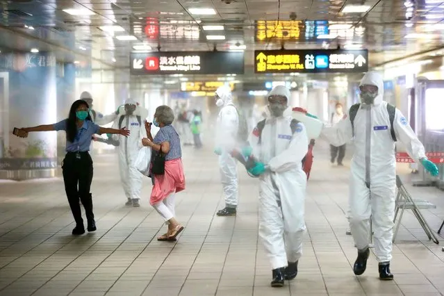 A passenger is guided away from the military personnel spraying disinfectant inside the Taipei Main Station, in Taipei, Taiwan, 18 May 2021. The rising number of Covid-19 cases prompted the government to raise the alert level 3 and promote working from home. (Photo by Ritchie B. Tongo/EPA/EFE)