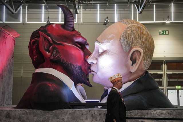 A carnival float depicts Russia's President Vladimir Putin kissing the devil at the presentation of this years satirical carnival floats for the Rose Monday Parade in Cologne, Germany, Tuesday, February 14, 2023. Hundreds of thousands will celebrate the traditional parade the streets of Germany's carnival capital next week on Shrove Monday. (Photo by Martin Meissner/AP Photo)