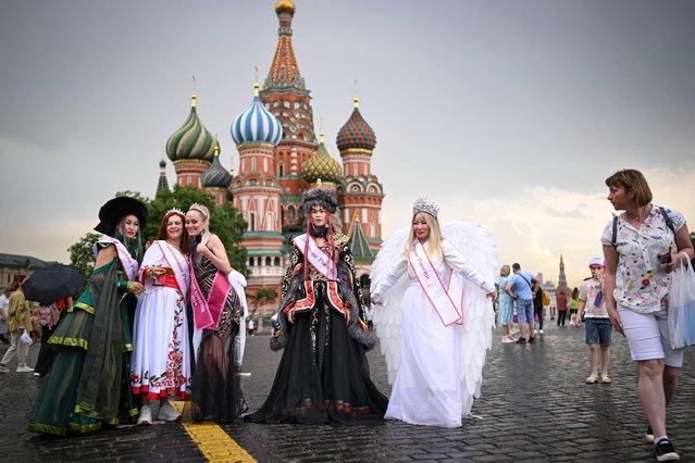 Women wearing costumes pose for a photograph at the Red Square near the Saint Basil's Cathedral in Moscow on June 6, 2024. (Photo by Natalia Kolesnikova/AFP Photo)