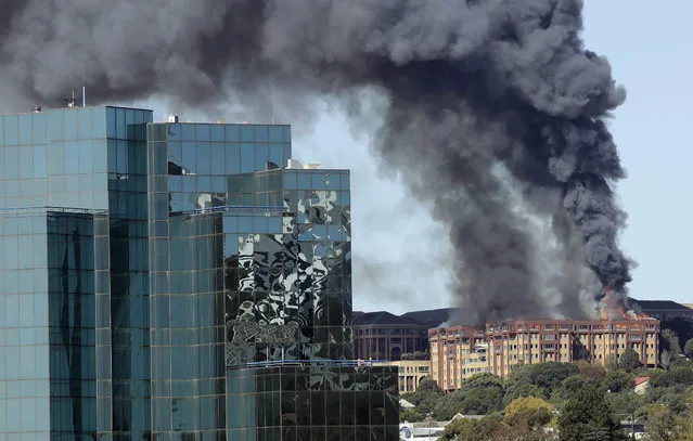 A pall of smoke drifts skyward as flames engulf the top floor of an office building in Johannesburg, South Africa, Tuesday, April 18, 2017, before being bought under control.  All people were successfully evacuated from the building and no injuries were reported. (Photo by Themba Hadebe/AP Photo)