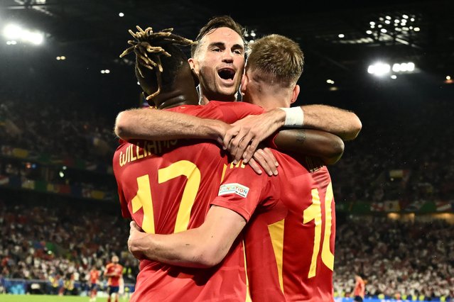 (L-R) Spain's midfielder #17 Nico Williams celebrates scoring his team's third goal with his teammates Spain's midfielder #08 Fabian Ruiz and Spain's forward #10 Daniel Olmo during the UEFA Euro 2024 round of 16 football match between Spain and Georgia at the Cologne Stadium in Cologne on June 30, 2024. (Photo by Angelos Tzortzinis/AFP Photo)