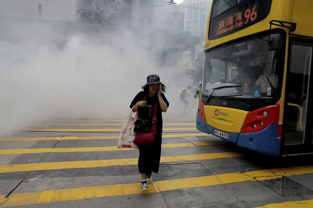 A woman walks near tear gas during a protest in Hong Kong on Sunday, September 29, 2019. (Photo by Kin Cheung/AP Photo)