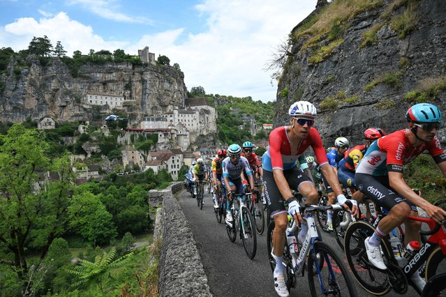 The pack of riders (peloton) cycles past the town of Rocamadour during the 12th stage of the 111th edition of the Tour de France cycling race, 203,6 km between Aurillac and Villeneuve-sur-Lot, southern central France, on July 11, 2024. (Photo by Marco Bertorello/AFP Photo)