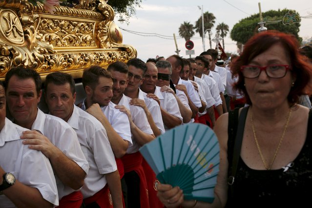 Men in traditional costumes carry a statue of the El Carmen Virgin on its way to be carried into the sea during a procession in Malaga July 16, 2015. (Photo by Jon Nazca/Reuters)