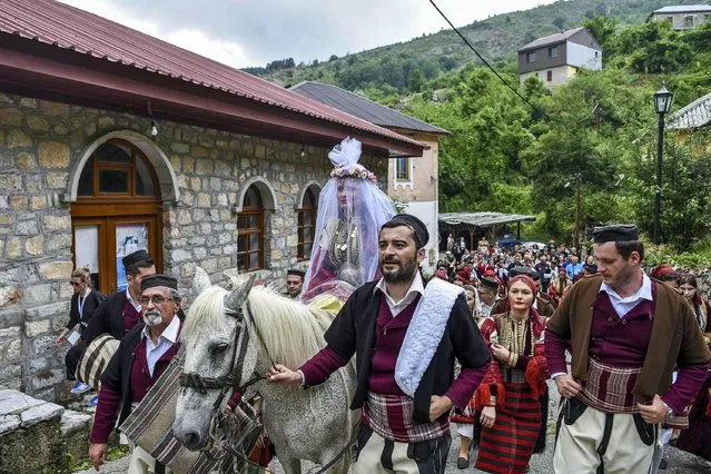 A bride, wearing a veil, rides a horse heading to the chuch during the traditional Galicnik Wedding ceremony in the Macedonia's western village of Galicnik, on July 18, 2021. Traditional Galicnik Wedding is held every year on the first weekend after the Orthodox St. Peter's day. (Photo by Robert Atanasovski/AFP Photo)