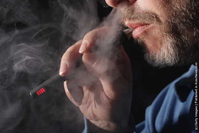 Owner of a shop that sells electronic cigarettes demonstrates how to use one
