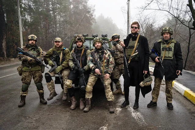 Kyiv region territorial defense unit pose for a picture after a military sweep to search for possible remnants of Russian troops after their withdrawal from villages in the outskirts of Kyiv, Ukraine, Friday, April 1, 2022. (Photo by Rodrigo Abd/AP Photo)