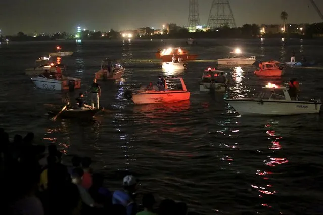 People gather along the banks of the Nile River during a search for the victims of a boat accident on the River Nile in the Warraq area of Giza, Egypt, early July 23, 2015. At least 15 people drowned when the small boat collided with a barge and capsized on the Nile River near Cairo on Wednesday night, Egypt's interior ministry said in a statement. (Photo by Mohamed Abd El Ghany/Reuters)