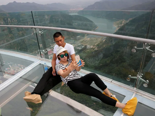 A couple takes a selfie on the glass sightseeing platform on Shilin Gorge in Beijing, China, May 27, 2016. (Photo by Kim Kyung-Hoon/Reuters)