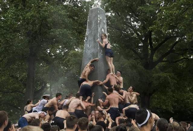 Midshipman work together during the Herndon Monument Climb at the United States Naval Academy in Annapolis, Maryland on May 22, 2017. Midshipman Joe McGraw, of Rockford, Illinois, placed the upperclassman hat on top of the monument after 2 hours, 21 minutes and 21 seconds. The Herndon Monument Climb is the traditional culmination of the plebe year, or first year, at the U.S. Naval Academy. The class must work together to retrieve a white plebs “dixie cup” hat off of the monument and replace it with an upperclassman's hat. (Photo by UPI/Barcroft Images)