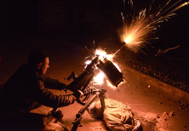 A Ukrainian serviceman shoots from automatic grenade launcher on position near the village of Peski, next to the city of Donetsk on October 20, 2014. Ukraine's armed forces on October 21, 2014, rejected allegations that they indiscriminately used banned “cluster bombs” in the six-month war against pro-Russian insurgents in the separatist east. (Photo by Chernyshev Aleksey/AFP Photo)