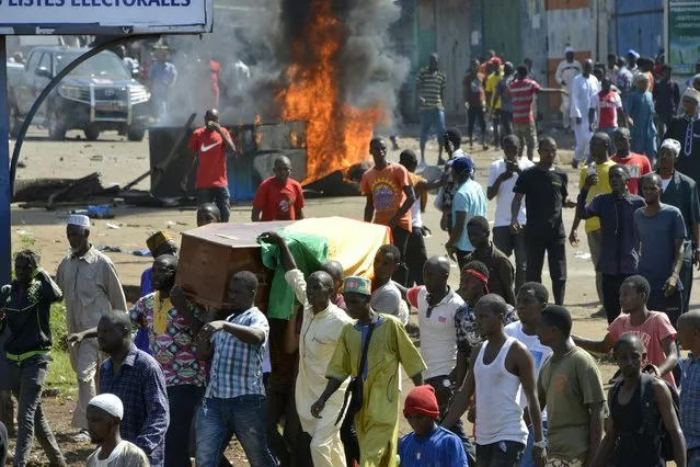 People carry coffins during the funeral after last street protests and unrest that resulted in nine deaths in Conakry, on November 4, 2019. Crowds of protesters marched through the Guinean capital of Conakry on October 24, 2019 in the latest round of demonstrations against President Alpha Conde, accused of trying to circumvent a bar on a third term in office. (Photo by Cellou Binani/AFP Photo)