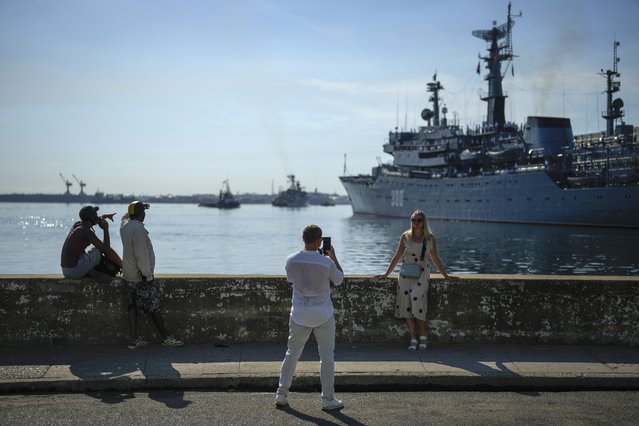 Tourists pose for photos backdropped by the Russian training ship “Smolnyy” as it arrives in the bay of Havana, Cuba, Saturday, July 27, 2024. (Photo by Ramon Espinosa/AP Photo)