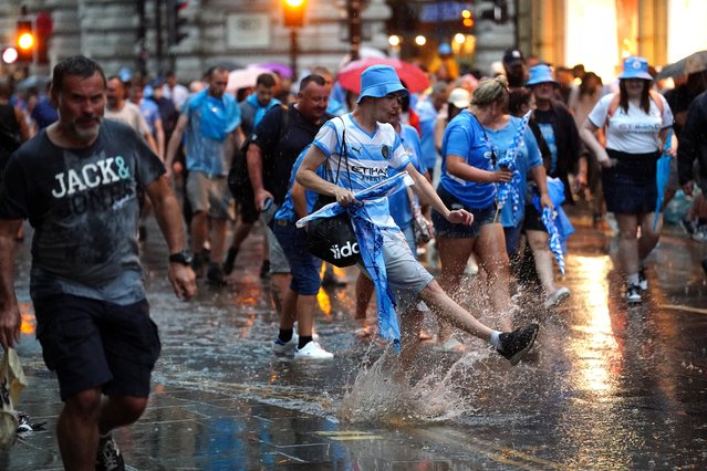 Manchester City fans in the rain during the Treble Parade in Manchester on Monday, June 12, 2023. Manchester City completed the treble (Champions League, Premier League and FA Cup) after a 1-0 victory over Inter Milan in Istanbul secured them Champions League glory. (Photo by David Davies/PA Images via Getty Images)