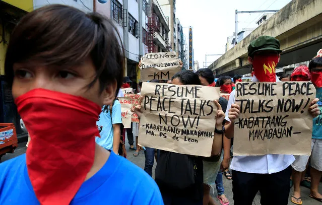 Supporters of the communist National Democratic Front (NDF) of the Philippines cover their faces and display placards as they call for the resumption of peace talks between the government and the Maoist-led rebels, during a protest along a main road in metro Manila, Philippines June 16, 2016. (Photo by Romeo Ranoco/Reuters)