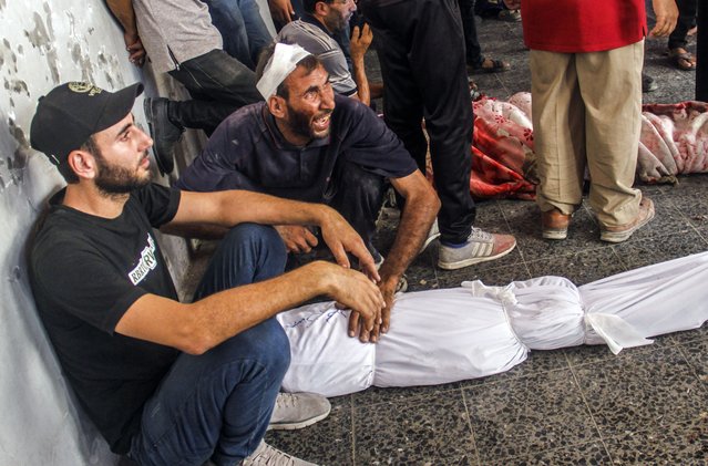 Internally displaced Palestinians mourn next to the bodies of relatives killed in an Israeli air strike in the Zaytoun area of Gaza City, 21 September 2024. According to the Palestinian Health Ministry in Gaza, at least 22 people were killed and dozens injured on 21 September after an Israeli strike hit a school in Gaza City which was being used as a shelter by internally displaced Palestinians. The Israeli Defense Forces (IDF) announced that the strike it conducted was targeting a Hamas control and command center, which was “embedded inside a compound that previously served as the Al Falah School”. More than 41,300 Palestinians and over 1,400 Israelis have been killed, according to the Palestinian Health Ministry and the Israel Defense Forces (IDF), since Hamas militants launched an attack against Israel from the Gaza Strip on 07 October 2023, and the Israeli operations in Gaza and the West Bank which followed it. (Photo by Mahmoud Zaki/EPA)