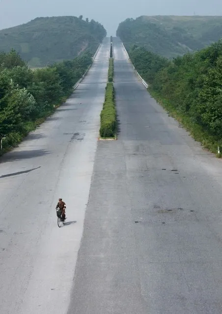 Yes, in North Korea, you can bike without danger on highways. Lot of peple try to stop cars but they need to wait for hours... When i asked to stop to take them as the tourist bus i had was empty, my guide refused, saying it was totally impossible to do this. (Photo by Eric Lafforgue/Exclusivepix Media)