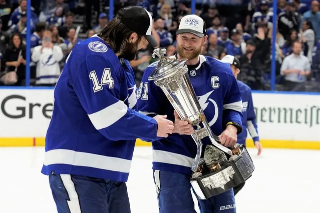 Tampa Bay Lightning center Steven Stamkos (91) shows left wing Pat Maroon (14) the Prince of Wales trophy after the team defeated the New York Rangers during Game 6 of the NHL hockey Stanley Cup playoffs Eastern Conference finals Saturday, June 11, 2022, in Tampa, Fla. The Lightning advanced to the Stanley Cup Finals. (Photo by Chris O'Meara/AP Photo)