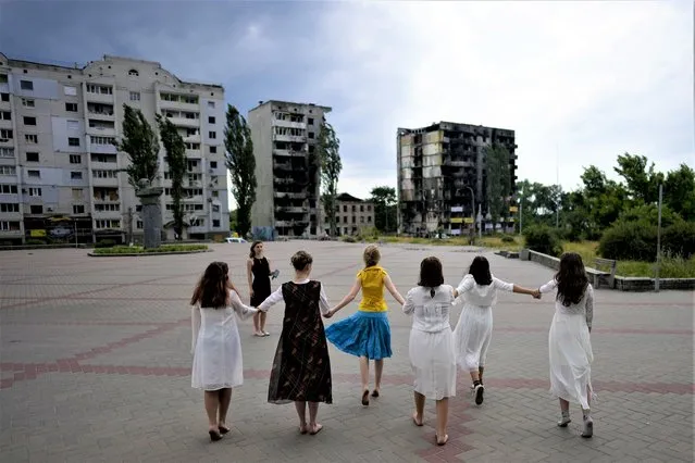 Girls dance near a building destroyed in Russian attacks, in Borodyanka, on the outskirts of Kyiv, Ukraine, Tuesday, June 21, 2022. (Photo by Natacha Pisarenko/AP Photo)