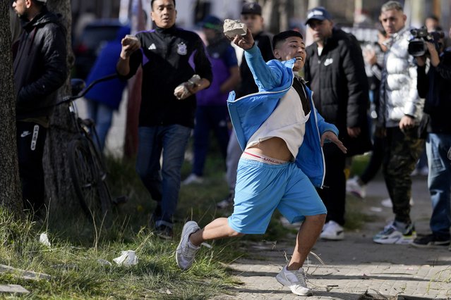 A demonstrator throws a rock at the police during a protest against the death of 11-year-old girl Morena Dominguez, who died from her injuries after criminals tried to rob her, outside a police station on the outskirts of Buenos Aires, Argentina, Wednesday, August 9, 2023. (Photo by Natacha Pisarenko/AP Photo)