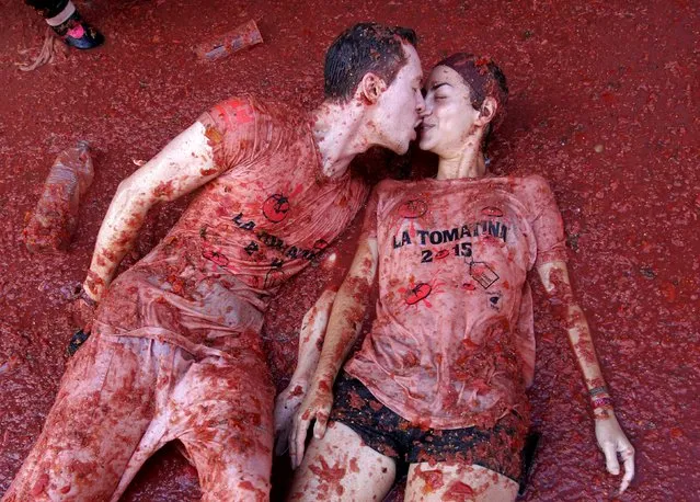 Revelers kiss each other while lying in tomato pulp after the annual “Tomatina” (tomato fight) in Bunol, near Valencia, Spain, August 26, 2015. (Photo by Heino Kalis/Reuters)