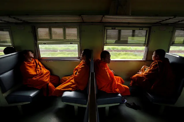 Buddhist monks ride a train in the direction of the ancient city of Ayutthaya outside Bangkok, Thailand July 14, 2016. (Photo by Jorge Silva/Reuters)
