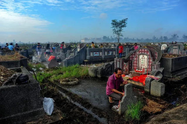 Ethnic Chinese Indonesians visit their ancestral graves at the Kubu Raya district cemetery in West Kalimantan, Indonesia on August 27, 2017. The local Chinese community visits the graves of their ancestors to honor them, believing that they will provide protection and blessings to the living. (Photo by AFP Photo/Stringer)