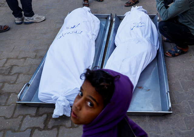 A boy looks on near the bodies of Palestinians killed in an Israeli strike, at Nasser hospital in Khan Younis in the southern Gaza Strip on November 17, 2024. (Photo by Mohammed Salem/Reuters)