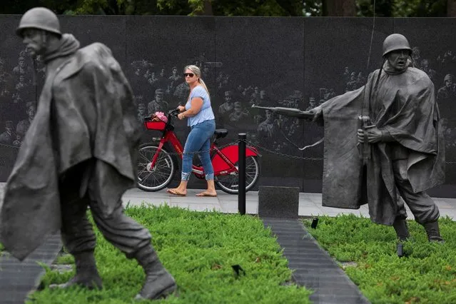 A visitor walks a bicycle through the newly renovated Korean War Veterans Memorial on the National Mall in Washington, U.S., July 31, 2022. (Photo by Tom Brenner/Reuters)