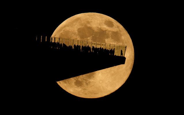 The full Beaver Supermoon rises behind the EdgeNYC outdoor observation deck at Hudson Yards in New York City on November 15, 2024, as seen from Hoboken, New Jersey. (Photo by Gary Hershorn/Getty Images)