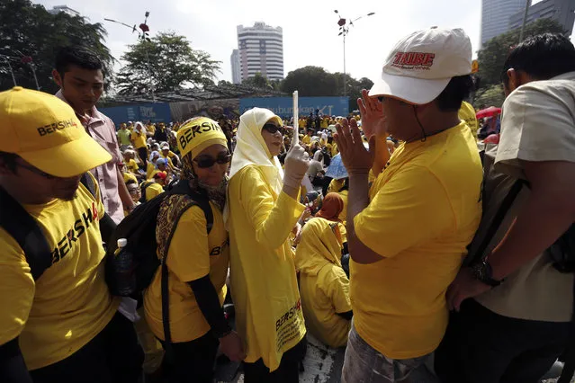 Malaysian opposition leader Wan Azizah, center joina thousand of  protesters at a rally organized by pro-democracy group “Bersih” (Clean) in Kuala Lumpur, Malaysia, Saturday, August 29, 2015. Malaysian activists are putting more pressure on embattled Prime Minister Najib Razak to resign with major street rallies this weekend following allegations of suspicious money transfers into his accounts. (Photo by Lai Seng Sin/AP Photo)