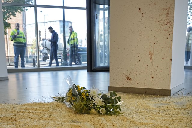 Flowers laid in tribute inside an office building in Brussels, Tuesday, October 17, 2023, at the scene close to where two Swedish soccer fans were shot by a suspected Tunisian extremist on Monday night. Police in Belgium have shot dead a suspected Tunisian extremist accused of killing two Swedish soccer fans in a brazen attack on a Brussels street before disappearing into the night on Monday. (Photo by Martin Meissner/AP Photo)