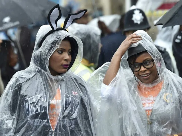 Revellers wear rain ponchos as they attend the Notting Hill Carnival in west London, August 25, 2014. (Photo by Toby Melville/Reuters)
