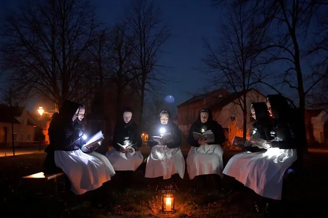 Women dressed in traditional clothes of the Slavic ethnic minority community of Sorbs meet early on Easter Sunday to sing in front of a church in Schleife, eastern Germany, April 12, 2020, as the spread of the coronavirus disease (COVID-19) continues. (Photo by Matthias Rietschel/Reuters)