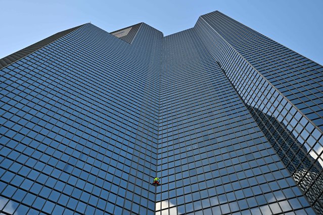 French skyscraper climber Alain Robert, known as the “French Spiderman”, climbs the Coupole Total tower (housing the Total Energy headquarters) in Puteaux at La Defense business district, west of Paris on November 6, 2023, to call for peace in the Middle East. (Photo by Miguel Medina/AFP Photo)