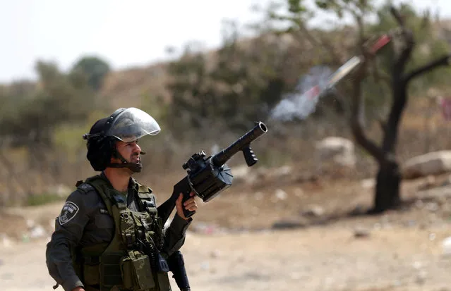 An Israeli border policeman fires a tear gas canister towards Palestinian protesters during clashes near Israel's Ofer Prison near the West Bank city of Ramallah August 3, 2016. (Photo by Mohamad Torokman/Reuters)