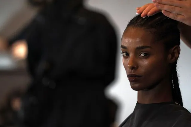 A model gets her hair done backstage before a Brandon Maxwell fashion show during Fashion Week, Tuesday, September 13, 2022, in New York. (Photo by Julia Nikhinson/AP Photo)
