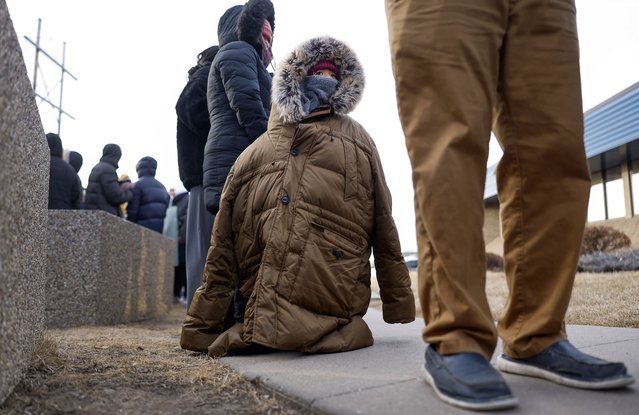 A child, bundled from the cold, stands in line to attend an immigration registration meeting outside of the Cedar Rapids U.S. Immigration and Customs Enforcement (ICE) office in Cedar Rapids, Iowa, on Tuesday, February 4, 2025. Photo by (Jim Slosiarek/The Gazette Via AP Photo)