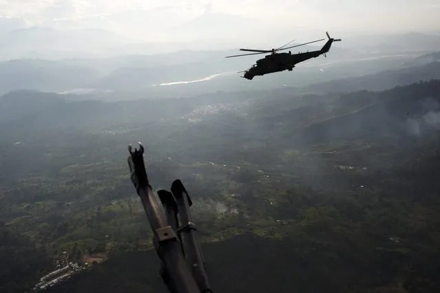 In this September 19, 2014 photo, a military helicopter flies over the VRAEM region, in Pichari, Peru. The region in the Apurimac, Ene and Mantaro River Valleys, or VRAEM, is the world's No. 1 coca-growing region. Security forces destroyed in the last two weeks more than 50 clandestine airstrips used by drug traffickers in the biggest offensive that seeks to combat the intense drug airlift to Bolivia. (Photo by Rodrigo Abd/AP Photo)
