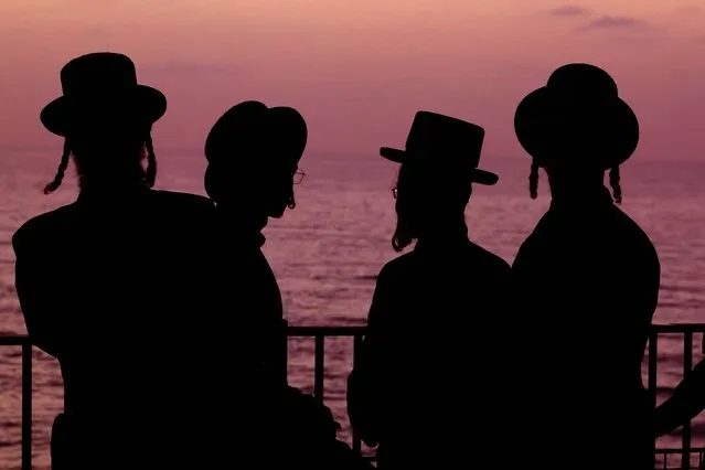 Ultra-Orthodox Jewish men and children perform the “Tashlich” ritual, during which “sins are cast into the water to the fish”, ahead of the Day of Atonement, or Yom Kippur, the most important day in the Jewish calendar, which this year will start at sunset on October 4, in the coastal Mediterranean city of Netanya, on October 3, 2022. (Photo by Jack Guez/AFP Photo)
