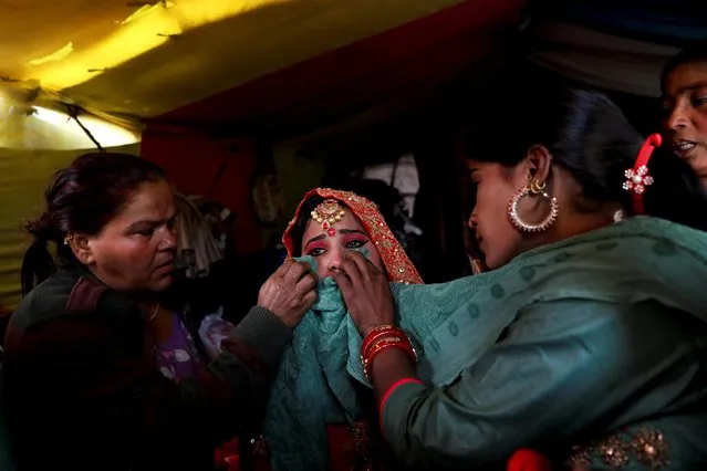 Asha, 18, a Hindu refugee from Pakistan, cries before her wedding as she remembers family members back in Pakistan, at a makeshift hut that was built using wood collected from surrounding trees, at a Hindu refugee settlement situated amongst a woodland area near Signature Bridge, a highway overpass in New Delhi, India, January 24, 2020. (Photo by Anushree Fadnavis/Reuters)