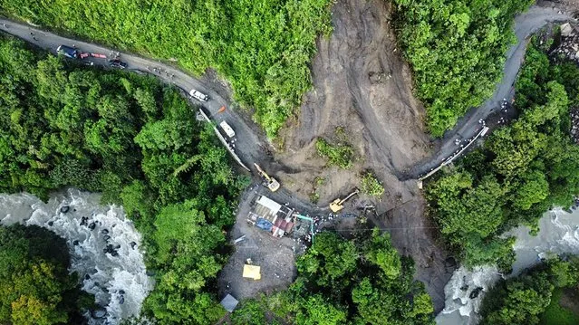 Aerial view of a landslide of a mountain in the sector El Ruso, Pueblo Rico municipality, in northwestern Bogota, Colombia, on December 5, 2022. A landslide engulfed a road on December 4 in Colombia, killing three people and leaving some 20 trapped in the mud, authorities said. Crews were searching for people riding on a bus, and a motorcycle caught up in the accident. (Photo by AFP Photo/Stringer)
