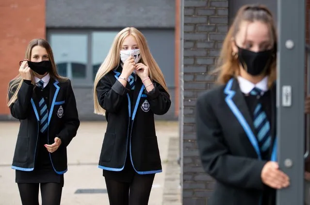 (L-R) Leah McCallum, Rebecca Ross and Sarah Watt, S4 students at St Columba's High School, Gourock put on their protective face masks on August 31, 2020, as the requirement for secondary school pupils to wear face coverings when moving around school comes into effect from today across Scotland. (Photo by Jane Barlow/PA Images via Getty Images)