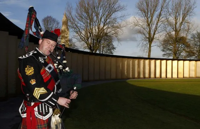 A bagpipe player attends a ceremony to inaugurate the new war memorial at Notre Dame de Lorette, an elliptical ring engraved with the names of the 580,000 men who died in northern France during the First World War, in Ablain-Saint-Nazaire November 11, 2014. (Photo by Michel Spingler/Reuters)