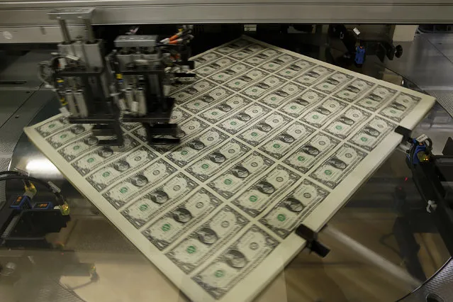 One dollar bills get rotated before being cut into individual pieces during production at the Bureau of Engraving and Printing in Washington November 14, 2014. (Photo by Gary Cameron/Reuters)