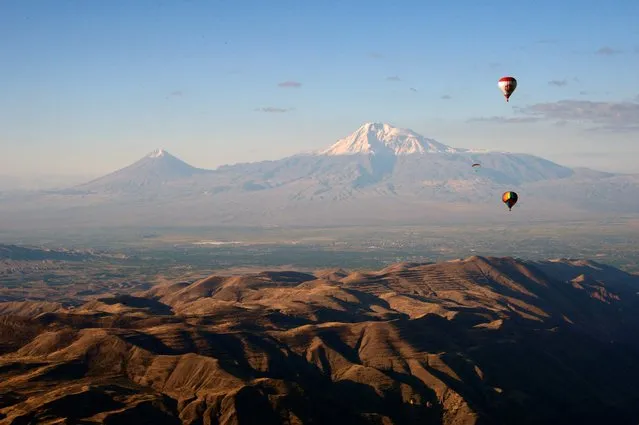 Ballooning enthusiasts fly their hot-air balloons in the sky near the settlement of Garni in the Kotayk region of Armenia during the “Discover Armenia from the sky” international ballooning festival, with Mount Ararat seen in the background, on October 12, 2022. Participants from Armenia, Brazil, Bulgaria, Germany, Kazakhstan, Poland and Russia take part in the festival. (Photo by Karen Minasyan/AFP Photo)