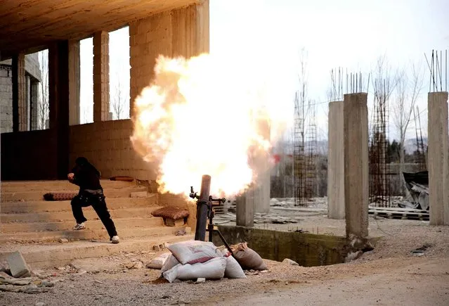 A Free Syrian Army fighter runs for cover during the firing of a mortar towards the Presidential palace in Ghouta area in Damascus, February 20, 2013. Three mortar bombs landed in the grounds of a presidential palace in northwest Damascus on Tuesday, Syrian activists said. (Photo by Mohammed Abdullah/Reuters)